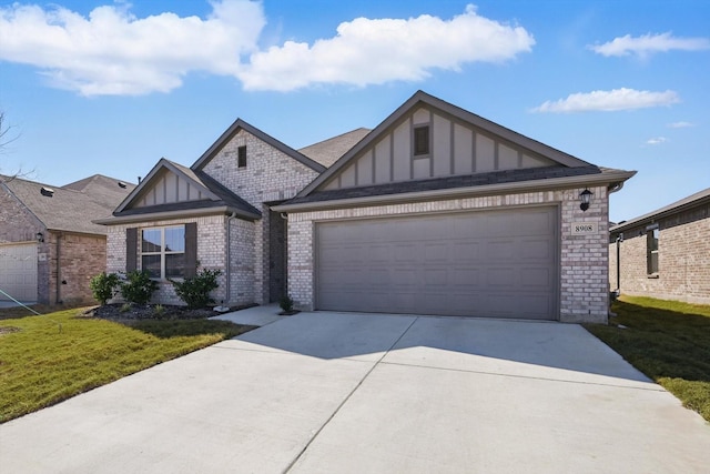 view of front facade with a front yard, driveway, a garage, board and batten siding, and brick siding