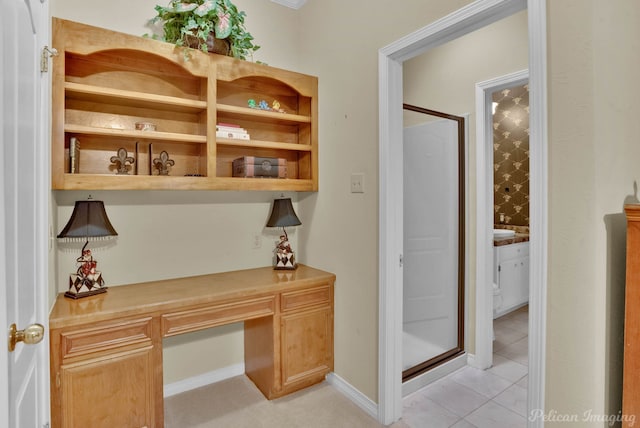 home office featuring light tile patterned floors, baseboards, and built in study area