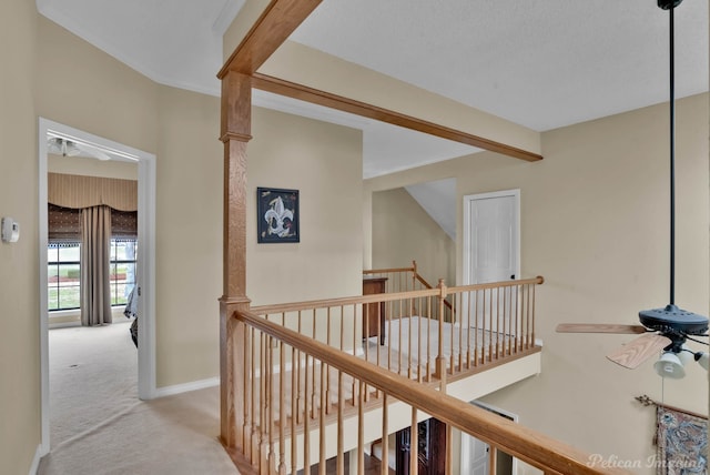 hall with carpet, beam ceiling, an upstairs landing, and baseboards