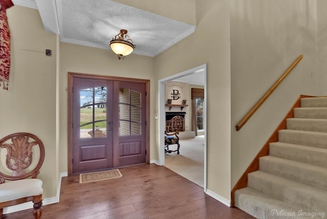 foyer featuring stairs, crown molding, french doors, and dark wood-type flooring