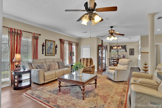 living area with visible vents, a textured ceiling, wood finished floors, and ornate columns