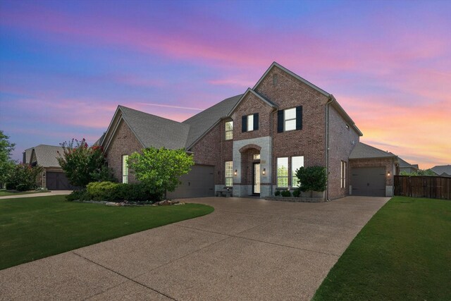 view of front of home featuring a garage, driveway, brick siding, and a front lawn