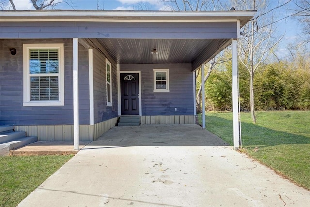 entrance to property with a lawn and concrete driveway