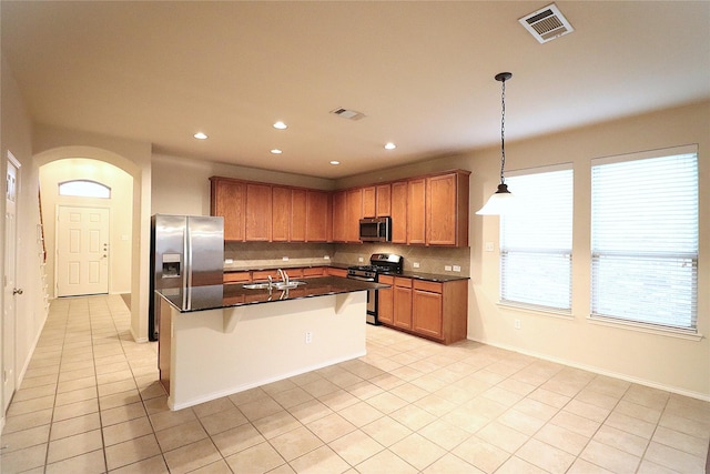 kitchen featuring visible vents, a sink, dark countertops, appliances with stainless steel finishes, and decorative backsplash