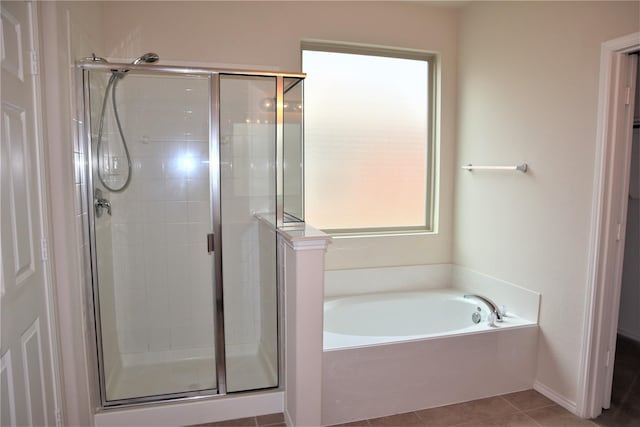 bathroom with tile patterned flooring, a shower stall, and a garden tub