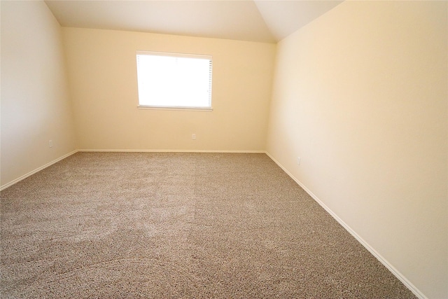 unfurnished room featuring vaulted ceiling, baseboards, and carpet floors