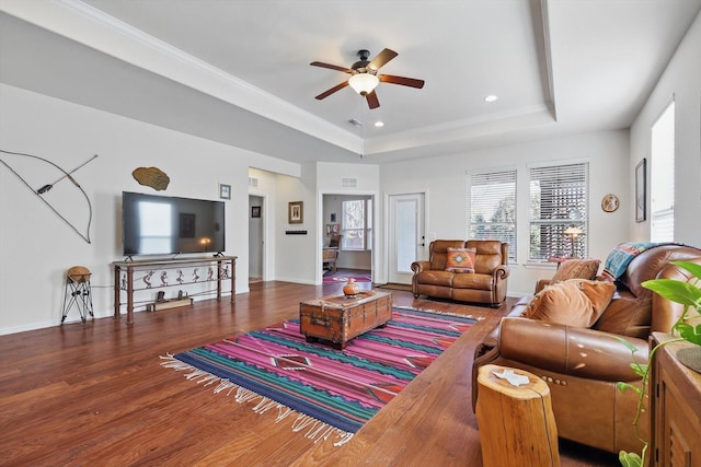 living room featuring a raised ceiling, a ceiling fan, wood finished floors, recessed lighting, and baseboards