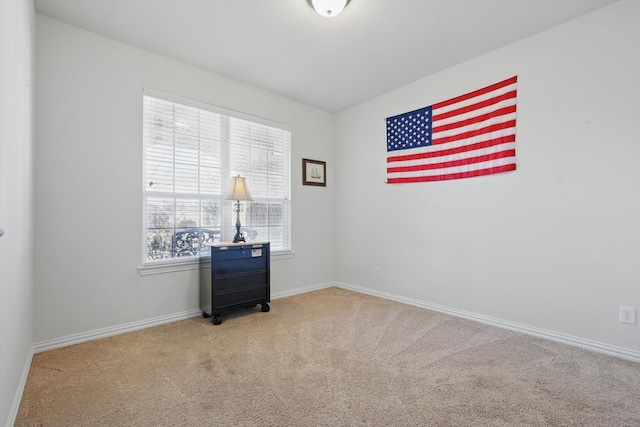 spare room featuring baseboards and carpet flooring