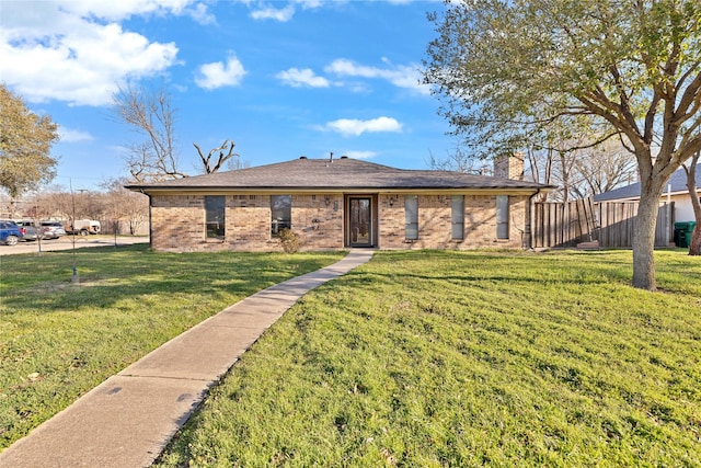 ranch-style home with brick siding, a chimney, a front yard, and fence