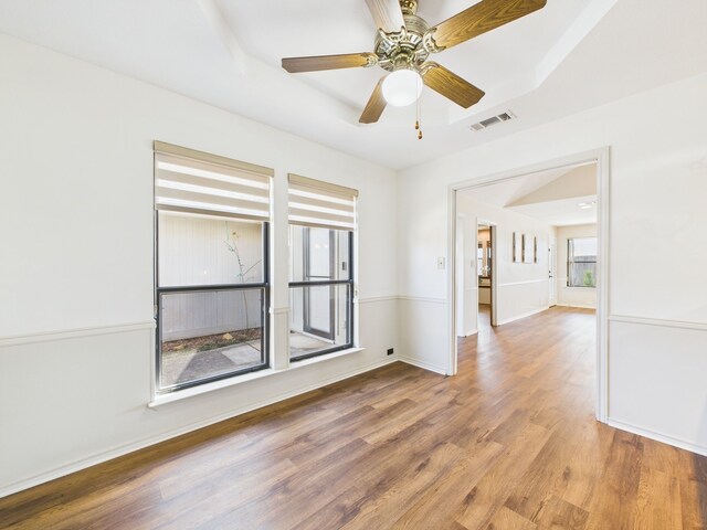 unfurnished room with light colored carpet, baseboards, a tray ceiling, and a ceiling fan