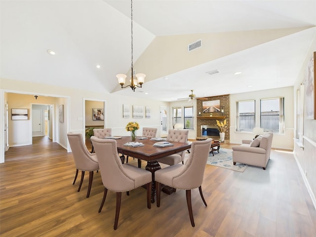 dining room with visible vents, plenty of natural light, a fireplace, and wood finished floors