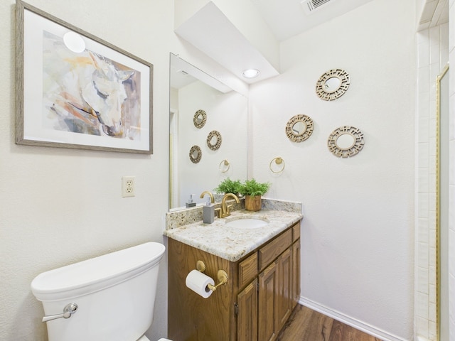 bathroom featuring toilet, vanity, and wood finished floors