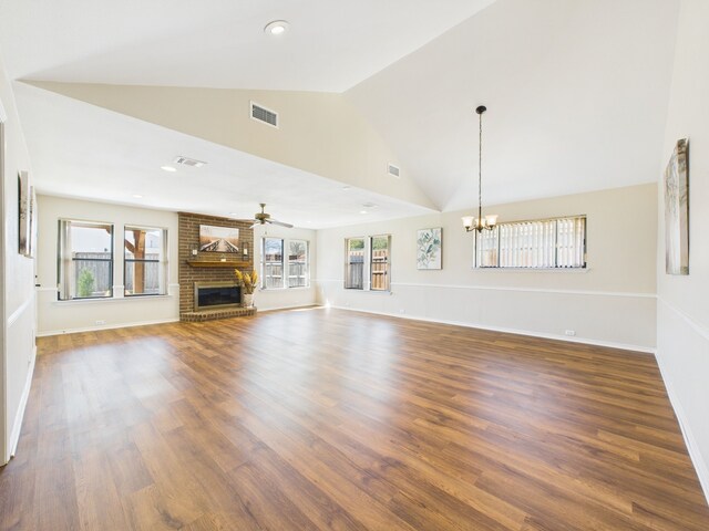 empty room featuring baseboards, wood finished floors, lofted ceiling, and a chandelier