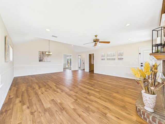 kitchen with brown cabinetry, a peninsula, stainless steel appliances, a brick fireplace, and light wood-type flooring