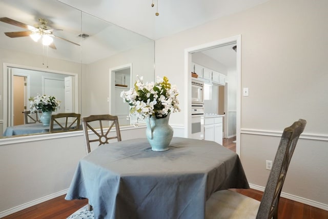 dining area featuring a ceiling fan, wood finished floors, visible vents, and baseboards