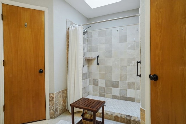 full bathroom with a skylight and a tile shower