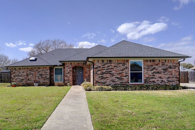 view of front facade featuring brick siding and a front yard