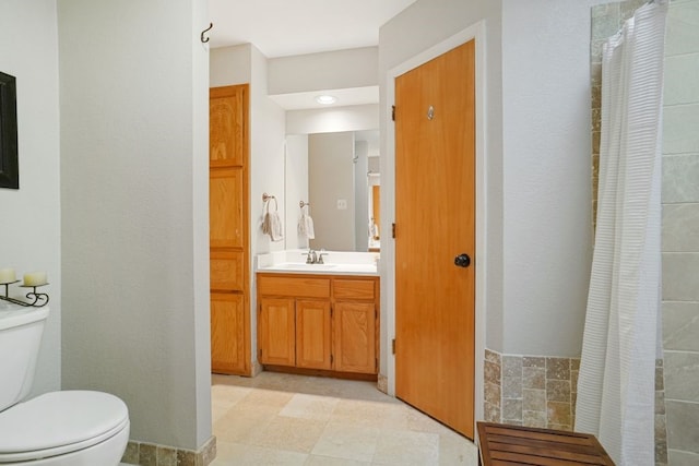 full bath with tiled shower, toilet, and vanity