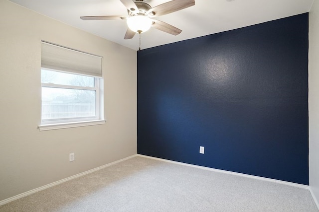 spare room featuring ceiling fan, baseboards, and carpet floors