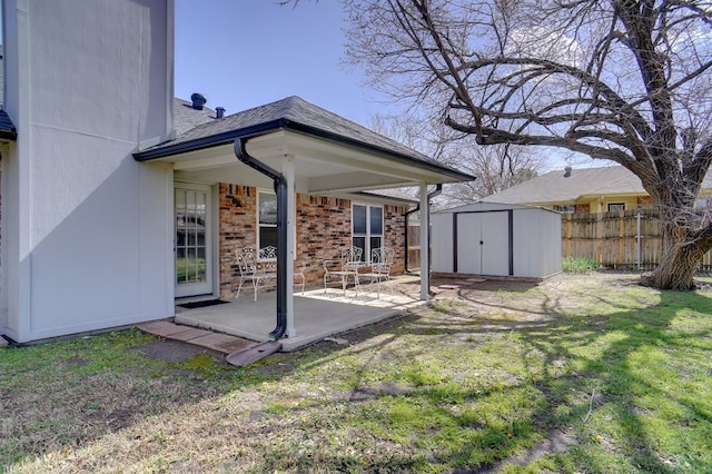 back of house featuring fence, an outdoor structure, a storage shed, a patio area, and brick siding