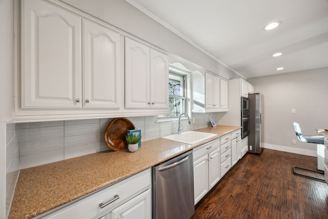 kitchen with a sink, decorative backsplash, stainless steel dishwasher, and white cabinetry