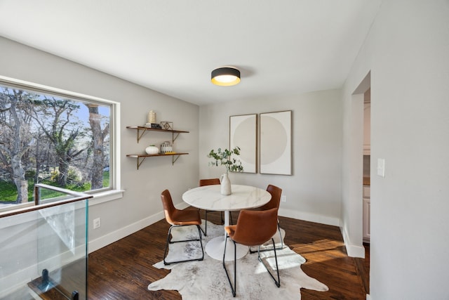 dining area with baseboards and wood finished floors