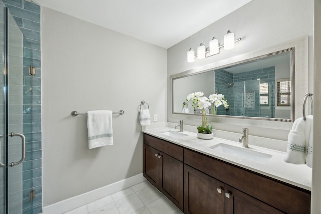 bathroom featuring double vanity, a stall shower, baseboards, and a sink