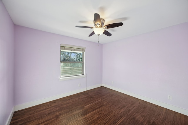 empty room featuring baseboards, ceiling fan, and dark wood-style flooring