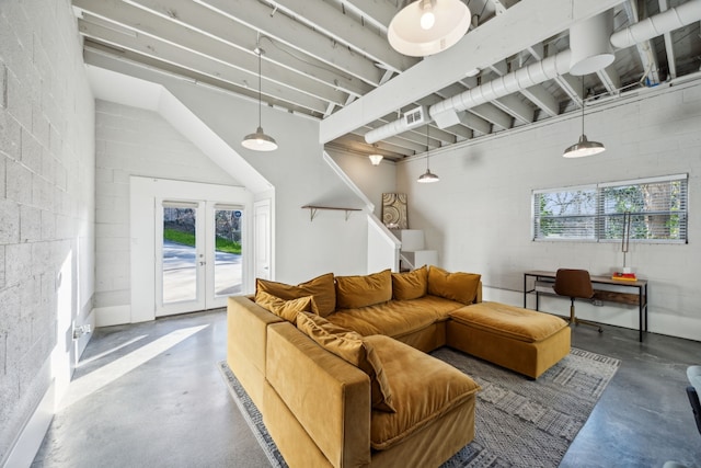 living room with visible vents, french doors, stairway, concrete block wall, and concrete flooring