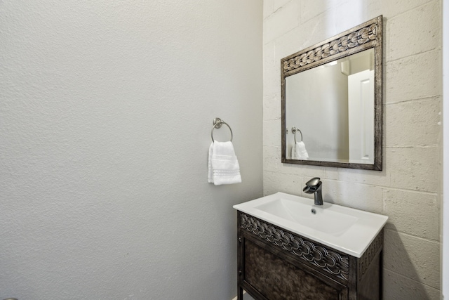 bathroom with vanity and concrete block wall