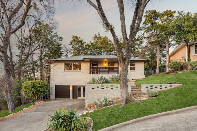 view of front facade with a front yard, stairway, fence, driveway, and a garage