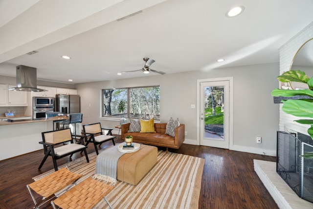 living room with dark wood finished floors, recessed lighting, baseboards, and a fireplace