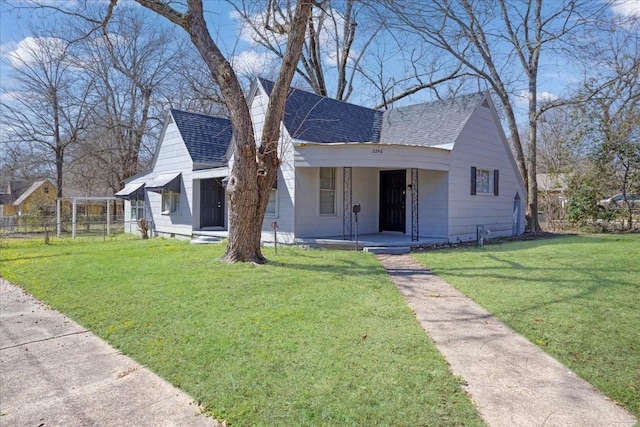 bungalow featuring covered porch, a front yard, roof with shingles, and fence