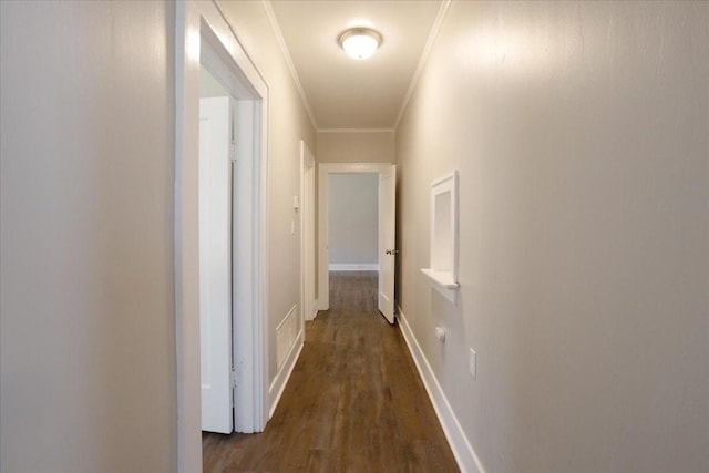 corridor with baseboards, dark wood finished floors, and crown molding