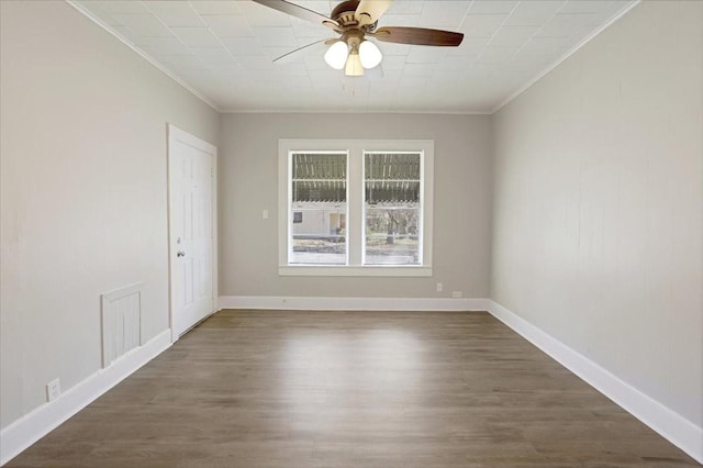 spare room with a ceiling fan, dark wood-style floors, baseboards, and ornamental molding