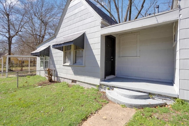 property entrance featuring a yard, fence, and crawl space