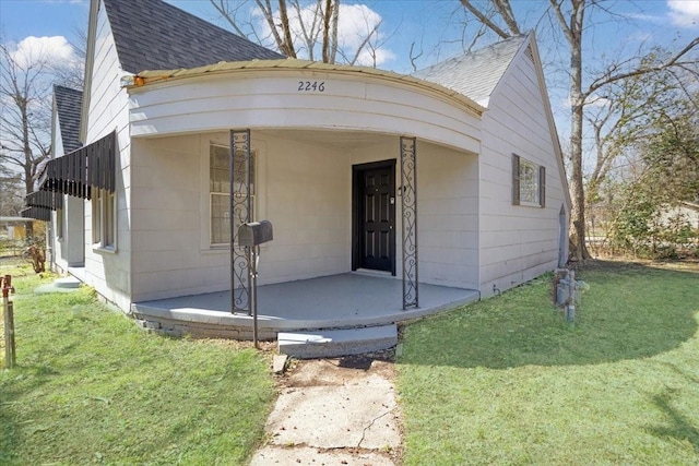 view of front of house with a front yard and roof with shingles