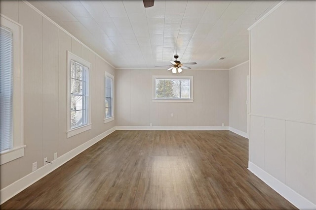 unfurnished room featuring baseboards, wood finished floors, a ceiling fan, and ornamental molding