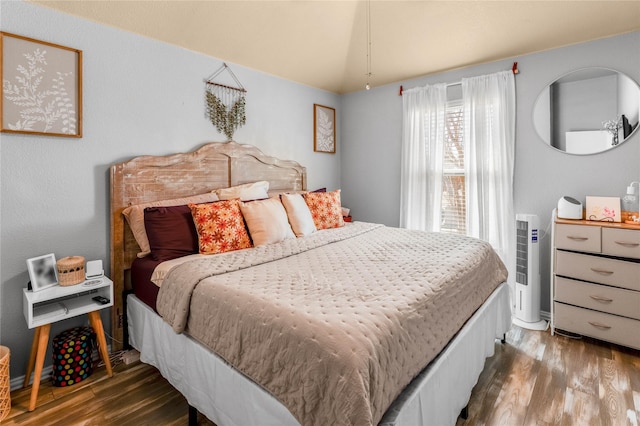 bedroom with lofted ceiling and wood finished floors