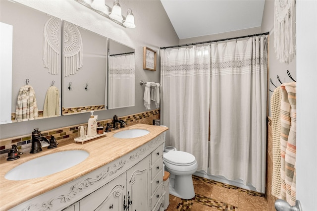 full bath featuring a sink, decorative backsplash, toilet, and double vanity