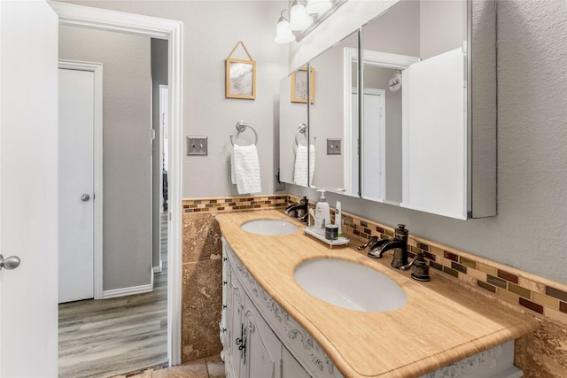 bathroom with tile walls, double vanity, and a sink