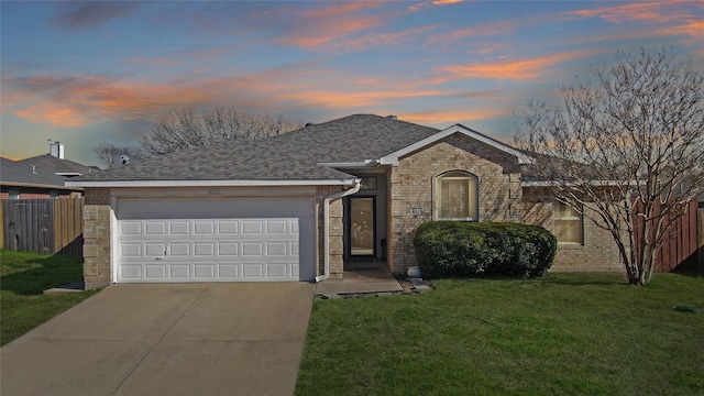 single story home with a front yard, fence, driveway, an attached garage, and brick siding