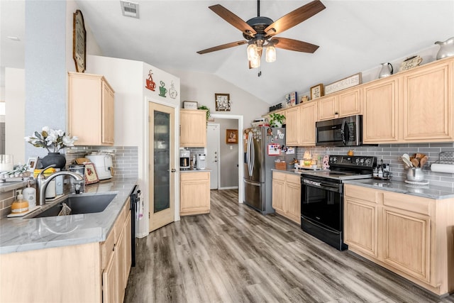 kitchen featuring visible vents, light brown cabinets, black appliances, and a sink