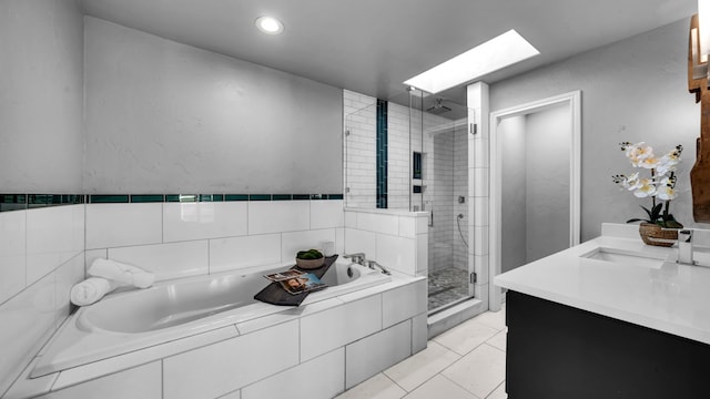 bathroom with vanity, a skylight, tile patterned flooring, a shower stall, and a garden tub