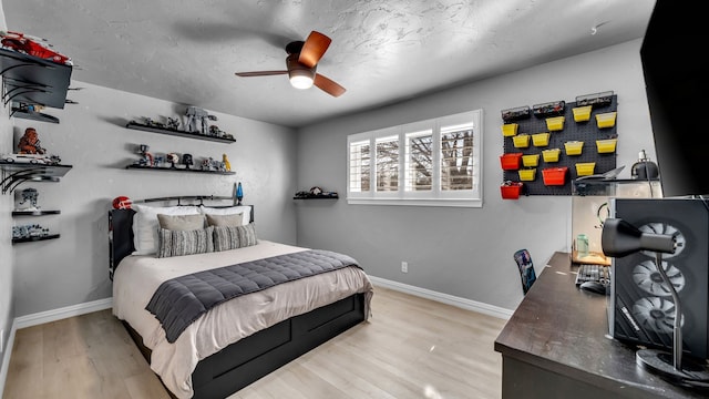 bedroom featuring ceiling fan, baseboards, and wood finished floors