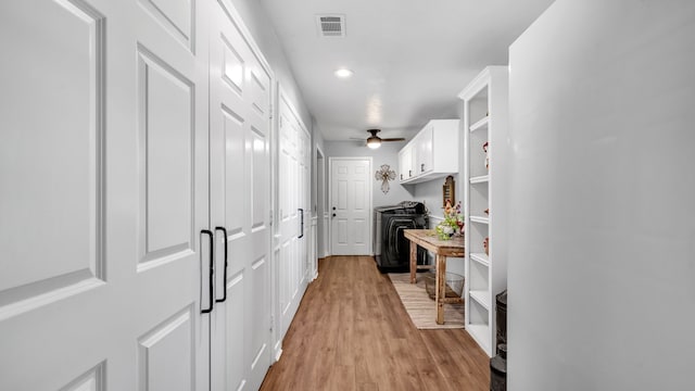 hall featuring light wood-type flooring and visible vents