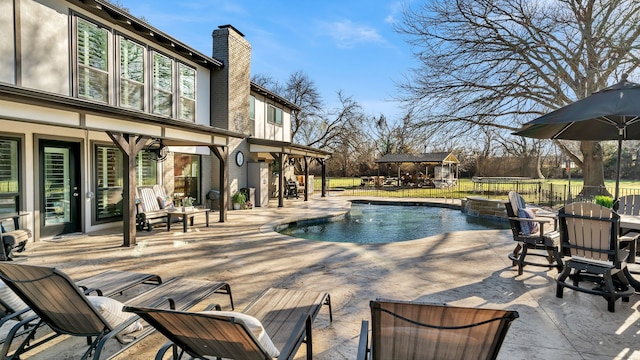 view of swimming pool featuring outdoor dining space, a trampoline, fence, a fenced in pool, and a patio area