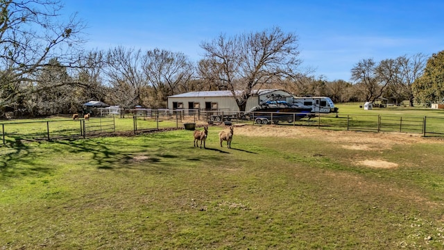 view of yard with an outbuilding, a rural view, and fence