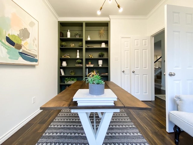 dining room featuring built in features, baseboards, wood finished floors, and crown molding