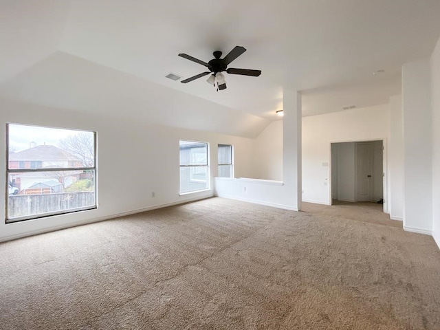 carpeted empty room featuring lofted ceiling, plenty of natural light, visible vents, and ceiling fan